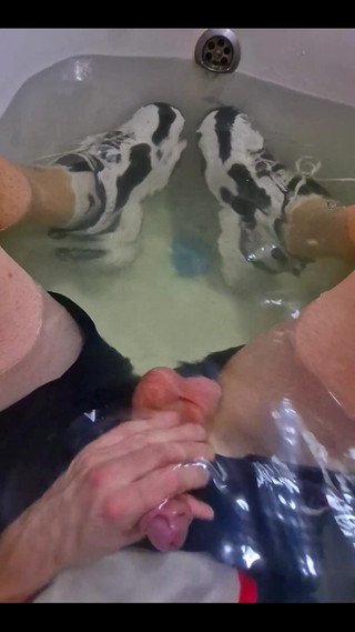 Wearing a Soccer Uniform and Nike Sneakers in Relaxing in a Tub Full of Water